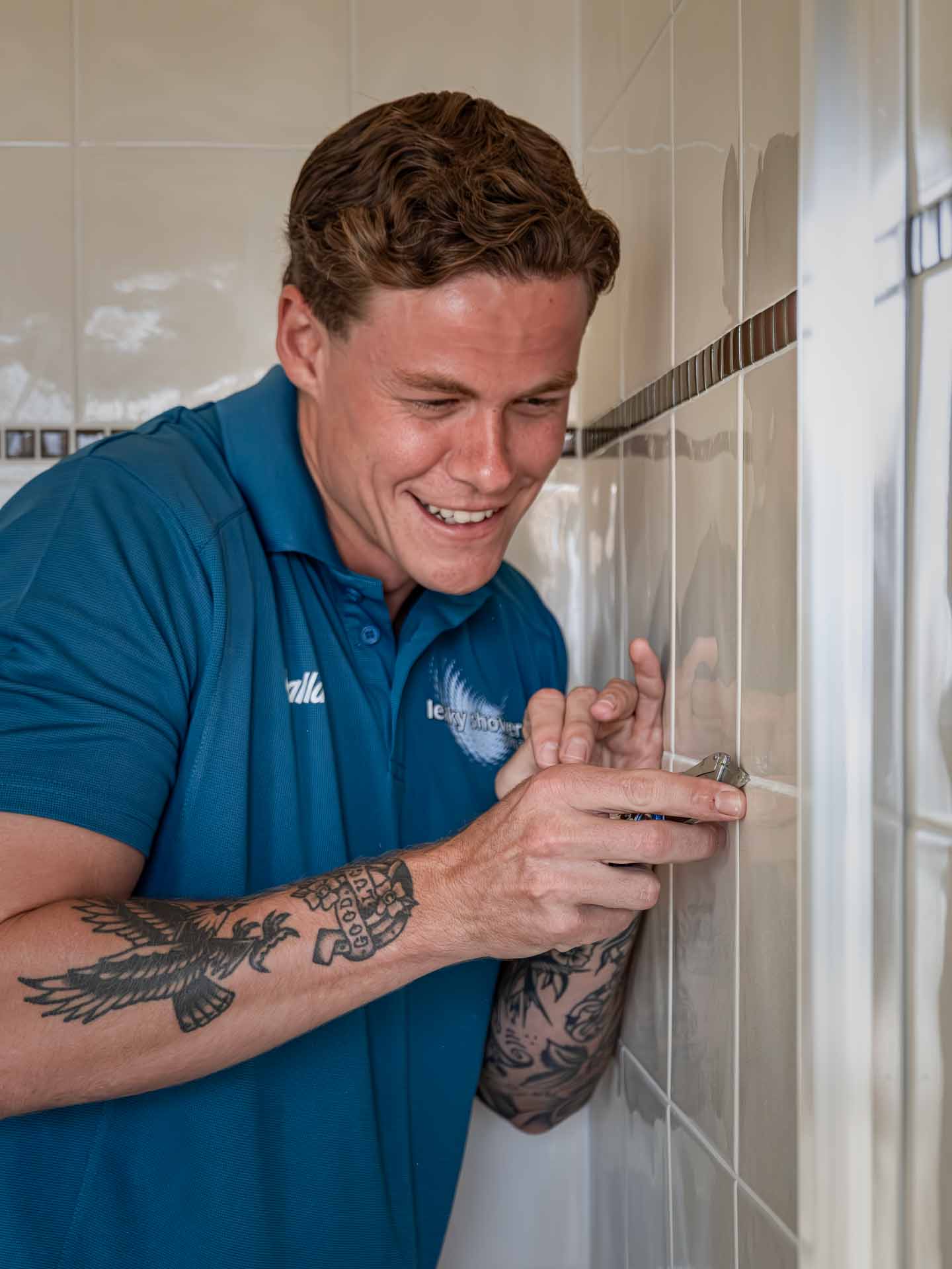 Leaky Showers technician Technicial fixing tiles in bathroom